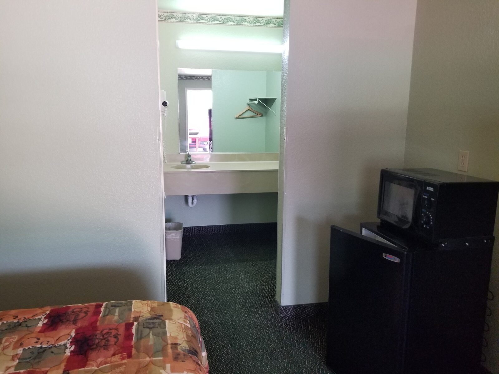 King Room interior at Haltom Inn — sunburst headboard with open bathroom view